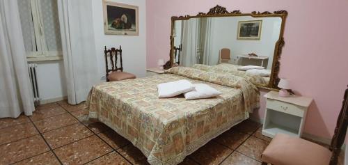 1 Schlafzimmer mit 2 Betten und einem Spiegel in der Unterkunft La casa di Chiara in Rom