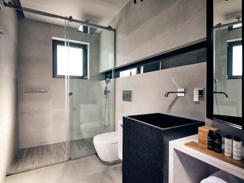 a bathroom with a toilet and a glass shower at Sueño LUXURY VILLA, in Argasi 180 Iconic Sea View in Argasi