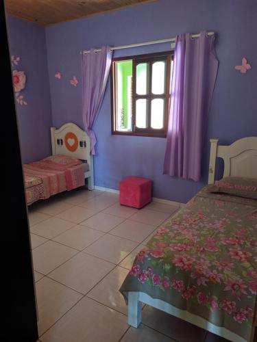 - une chambre avec 2 lits et une fenêtre dans l'établissement Village do Capão, à Vale do Capão