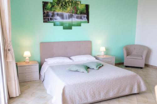 um quarto com uma cama branca e uma cadeira em Sorrento Hills em Sorrento