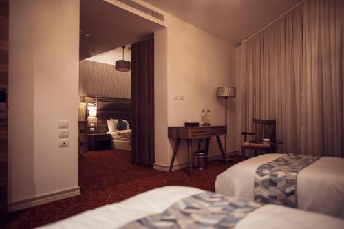 Habitación de hotel con 2 camas y escritorio en Yaldiz Palace Hotel en Nablus