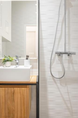 une salle de bain avec un lavabo et une douche dans l'établissement Le Cocon Part-Dieu, à Lyon