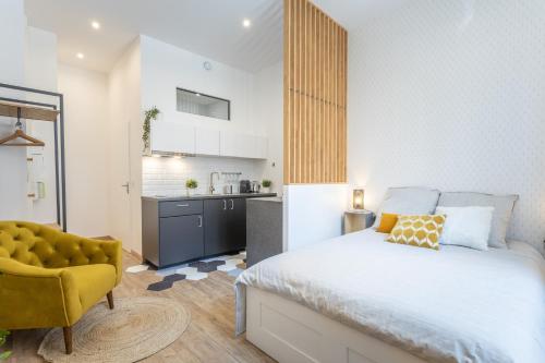 - une chambre avec un lit et une chaise jaune dans l'établissement Le Cocon Part-Dieu, à Lyon