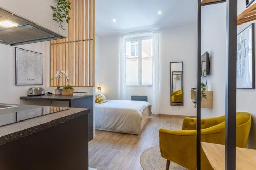 een slaapkamer met een bed en een keuken met een bureau bij Le Cocon Part-Dieu in Lyon