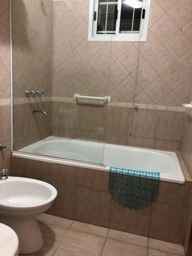 ein Badezimmer mit Badewanne und Toilette in der Unterkunft Saint Michel Departamentos para turismo in Alta Gracia