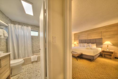 a hotel room with a bed and a bathroom at Club Lux Resort By The Beach in Deerfield Beach