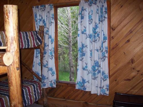 a room with a window in a log cabin at Cabañas Auquin Lemu in Lago Puelo