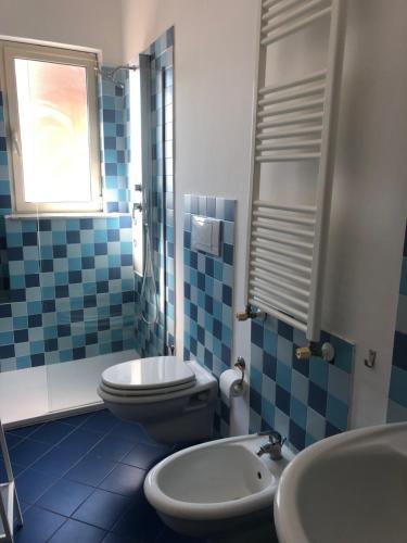 a blue and white bathroom with a toilet and a sink at FOUR SEASONS in Nicolosi