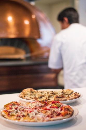 two pizzas on plates on a counter in a kitchen at Warwick Denver in Denver