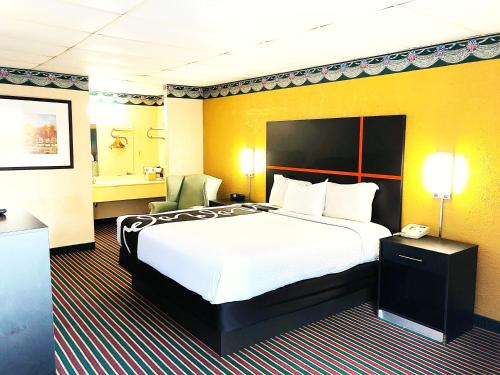 Rodeway Inn في غادسدن: غرفه فندقيه سرير كبير وتلفون