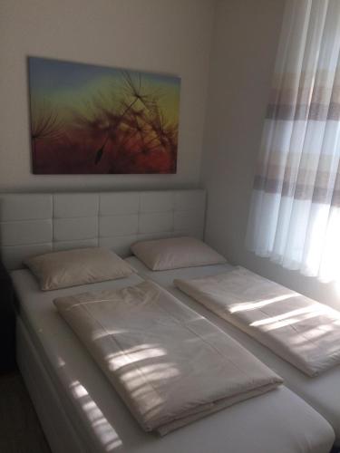 dwa łóżka w pokoju z obrazem na ścianie w obiekcie 1,5 Zimmer Appartement w mieście Winterthur