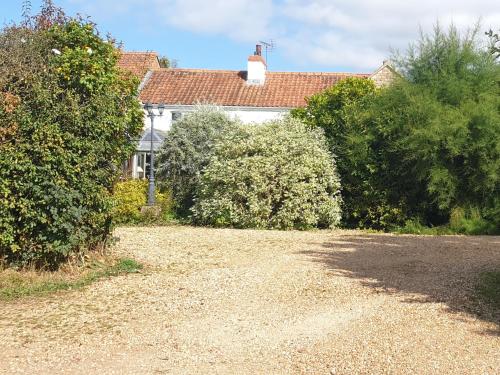 a house with a gravel driveway in front of a house at The Nest at Bramble Cottage Lacock in Lacock