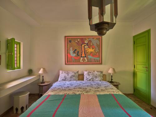 - une chambre avec un lit et une peinture murale dans l'établissement Riad Volubilis, à Marrakech