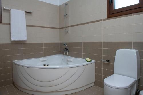 y baño con bañera y aseo. en Kallizoni villa, en Pafos