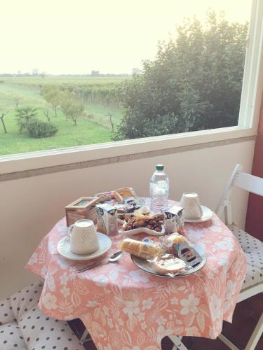 a table with a plate of food and a window at Villa Sofia in Pramaggiore
