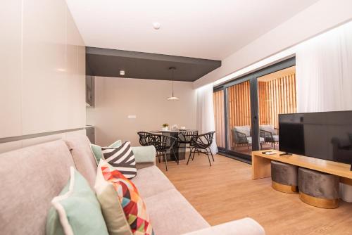 a living room with a couch and a television at Villa Esmeralda in Ponta Delgada
