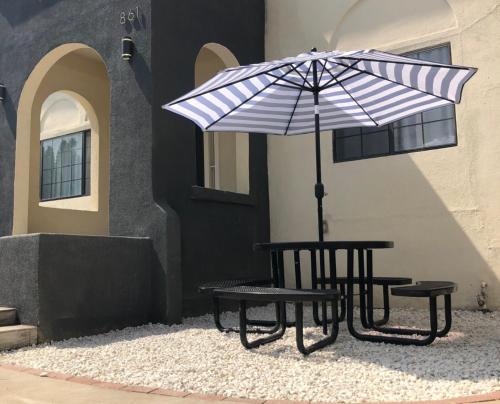 a picnic table with an umbrella and two benches at 8th and Ardmore in Los Angeles