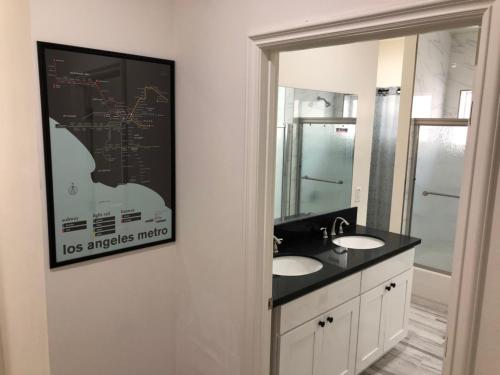 Baño con 2 lavabos y una foto en la pared en 8th and Ardmore en Los Ángeles