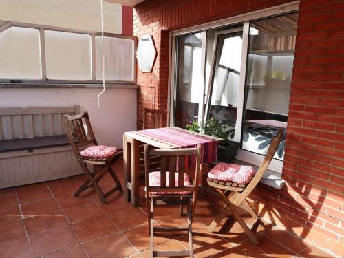 a patio with a table and chairs on a balcony at Ático con terraza céntrico Oviedo in Oviedo