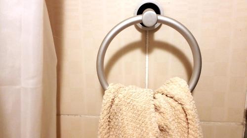 a towel hanging on a towel rack in a shower at Private Room In Apartment with Sea & Hilton View in Alexandria