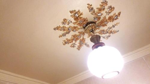 a chandelier hanging from a ceiling with a light at Private Room In Apartment with Sea & Hilton View in Alexandria