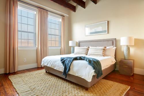 um quarto com uma cama com 2 janelas e um tapete em Sonder The Congress em Savannah