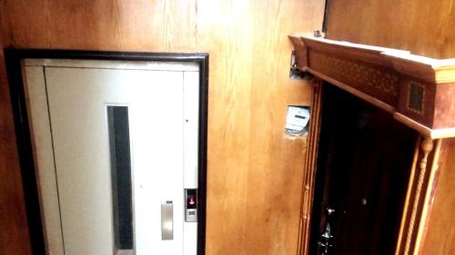 a door in a room with a wooden wall at Private Room In Apartment with Sea & Hilton View in Alexandria