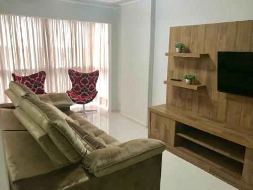- un salon avec un canapé et une télévision dans l'établissement MARAVILHOSO apartamento QUADRA MAR em BC, à Balneário Camboriú