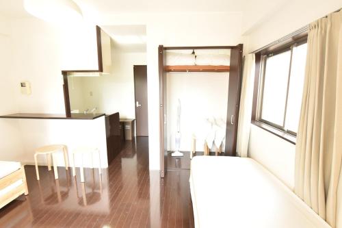 a room with a bed and a table and a window at Enzo Shin-Osaka C in Osaka