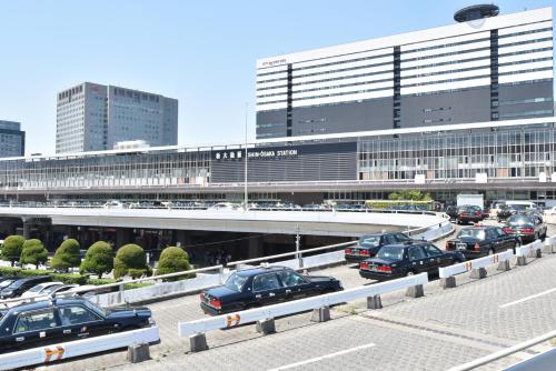 a parking lot with cars parked in front of a building at Enzo Shin-Osaka C in Osaka