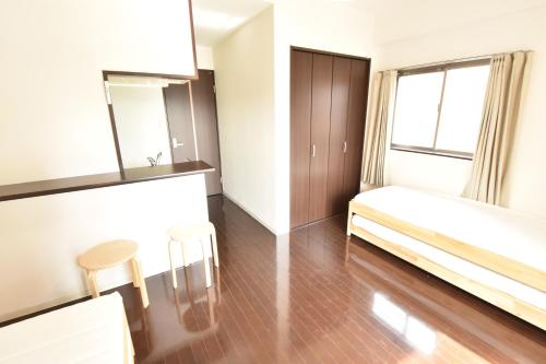 a bedroom with a bed and a table and chairs at Enzo Shin-Osaka C in Osaka