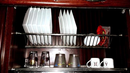 a shelf with several bottles and cups on it at Private Room In Apartment with Sea & Hilton View in Alexandria