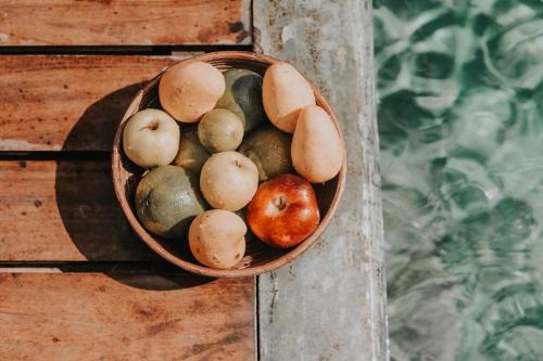 a bowl of fruit sitting on a wooden table at Casa de Olas Boutique Hotel in Puerto Escondido