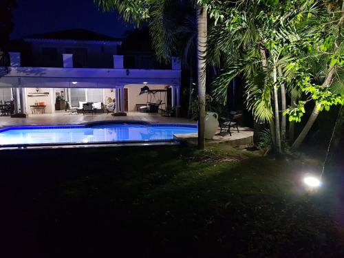 a house with a swimming pool at night at Villa M-6 Metro Country Club in Juan Dolio