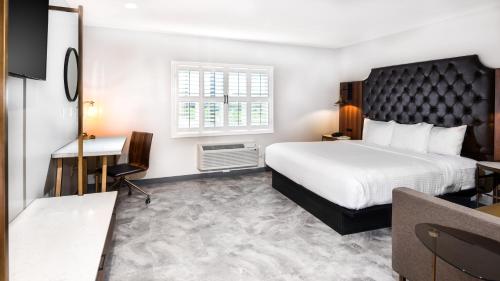 a hotel room with a bed and a desk at Hollywood Inn Suites Hotel in Los Angeles