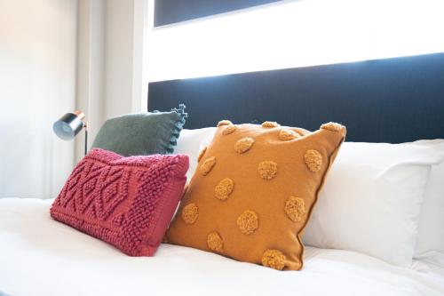 a group of pillows sitting on top of a bed at Horse and Jockey Hotel Homebush in Sydney