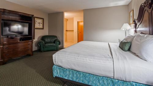 a hotel room with a bed and a flat screen tv at Baymont Inn and Suites by Wyndham Farmington, MO in Farmington