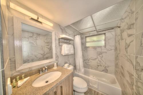 y baño con lavabo, aseo y bañera. en Riverside Apartments By The Beach en Pompano Beach
