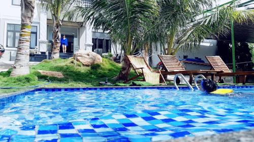 - une piscine avec 2 chaises et une table dans l'établissement Tôm Hùm Palace, à Cam Ranh
