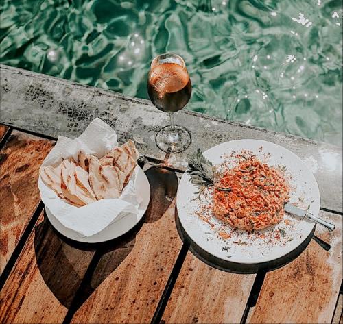 a table with two plates of food and a glass of wine at Casa de Olas Boutique Hotel in Puerto Escondido