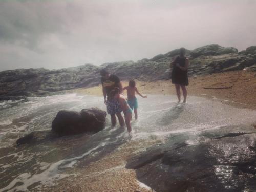 a group of people standing in the water on a beach at Turtle Paradise in Tangalle