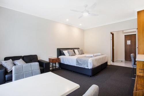 a hotel room with a bed and a couch at Manifold Motor Inn in Camperdown