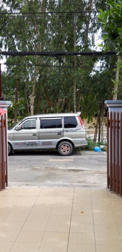 a silver van parked in a parking lot with trees at Lucky 190 in Chau Doc
