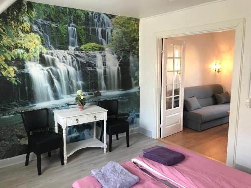 a bedroom with a waterfall mural on the wall at HotelPandekagehuset B&B in Nykøbing Sjælland