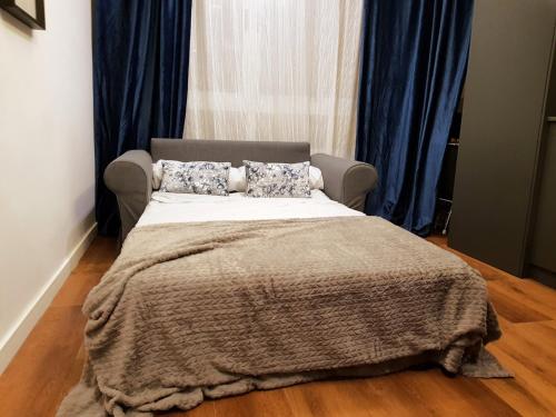 una camera da letto con un letto con una coperta e tende blu di new apartment canteras playa a Las Palmas de Gran Canaria