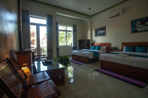 a bedroom with two beds and a table and chairs at Song Toan Hotel in Phong Nha