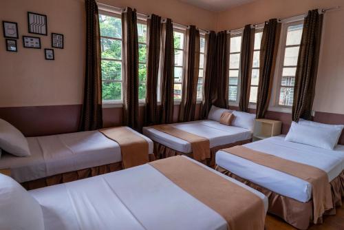 a room with two beds and windows at Old Orangewood Bed & Breakfast in Baguio