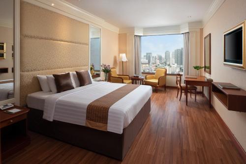 a hotel room with a bed and a view of the city at The Emerald Hotel in Bangkok