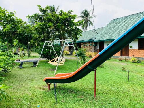 a playground with a slide and a swing at Crown Holiday Village near Marawila in Nattandiya