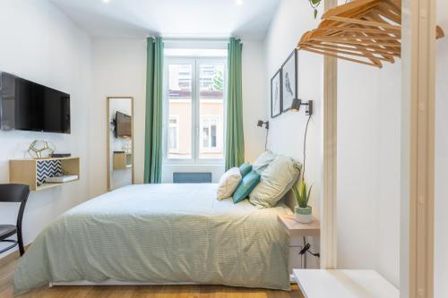 a bedroom with a large bed with blue pillows at Le Cocon Villette in Lyon